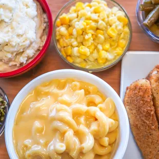 a bowl of macaroni and cheese with a side of greens