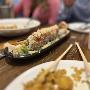 a plate of sushi and chopsticks