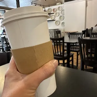 a hand holding a cup of coffee