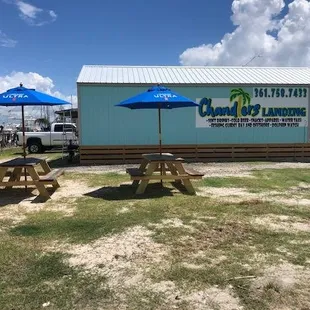 picnic tables and umbrellas in front of a building