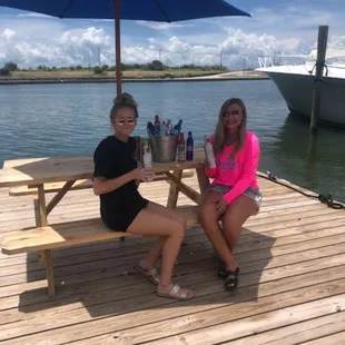two women sitting at a picnic table