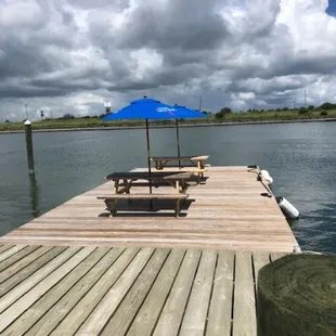 a picnic table and umbrella on a dock