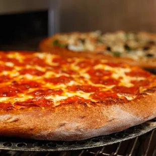 two pizzas on a rack