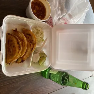 a plate of food and a bottle of beer on a table
