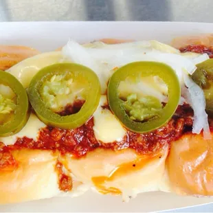 Chili hot dog with jalepenos.