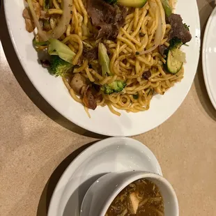 a plate of noodles with beef and broccoli