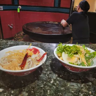two bowls of noodles and a bowl of salad