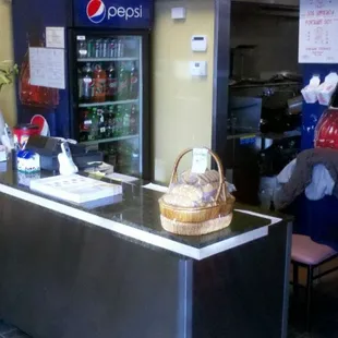 The front counter of the restaurant. Open and simple design, with a well-stocked drink fridge.