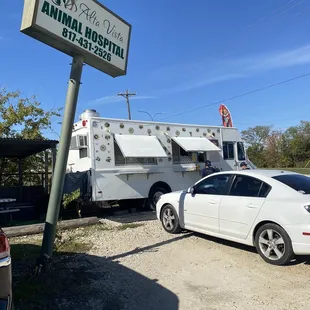 a white car parked in front of an animal hospital
