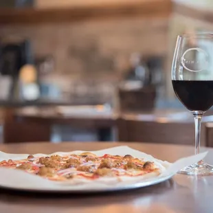 a plate of pizza and a glass of wine