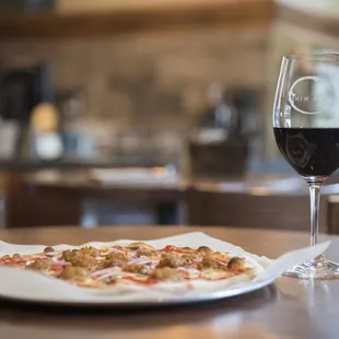 a plate of pizza and a glass of wine