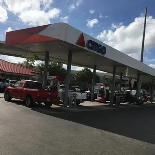 a red truck parked in front of a gas station