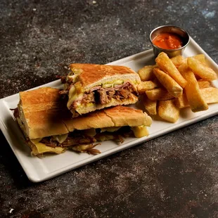 Cubano: roasted pork, ham, gruyere, pickle, dijon mustard, cuban bread - served with papas fritas