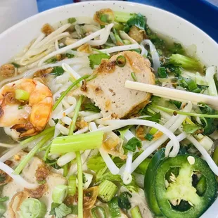 a bowl of noodle with shrimp and vegetables