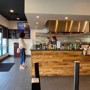 a woman standing at a counter in a restaurant