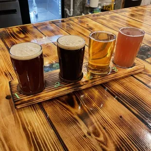 a flight of beers on a wooden table