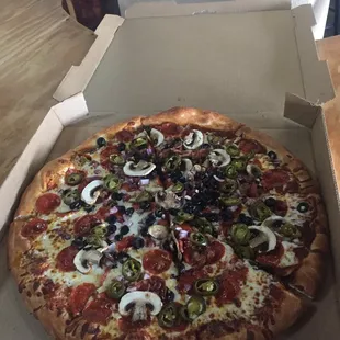 Pizza with mushrooms jalapeños black olives onions and pepperoni.
