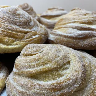 a pile of pastries with powdered sugar on top