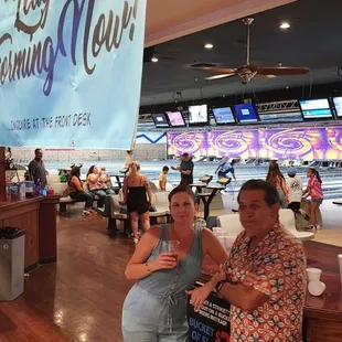 two people sitting at a bowling alley