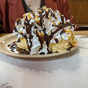 Impressive warm Brownie covered in ice cream topped with real whipped cream drizzled with chocolate sauce