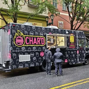a group of people standing in front of a food truck