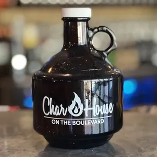 a black growler bottle with the char house on the boulevard logo