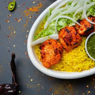 a plate of food with rice and sauce