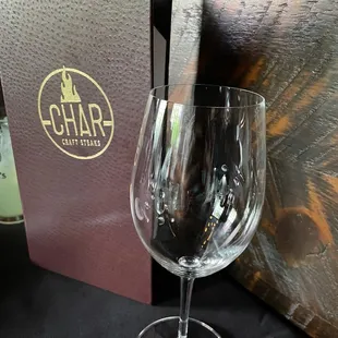 a glass of wine and silverware on a table