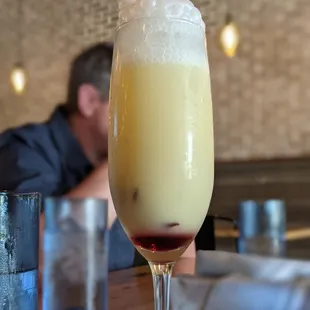 This is the Falkor - pineapple puree, coconut cream, dark rum and brut with an edible hibiscus flower kept in simple syrup.