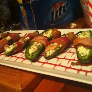 Snake bites: jalapeño poppers stuffed w/cream cheese, wrapped in bacon, over a bed of raspberry sauce