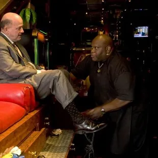 a man sitting on a red couch and a man sitting on a red chair