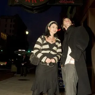 a man and a woman standing on a sidewalk