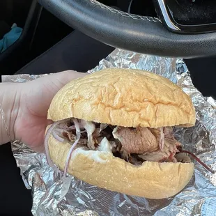 a person holding a sandwich in their hand