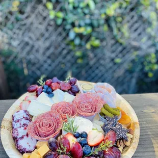 a platter of cheese, fruit, and meats