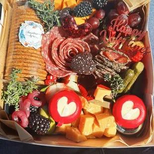 Charcuterie: meats, cheese, fruit, nuts, chocolates, candy, honey, jam, and crackers.