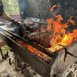 a man cooking meat on a grill