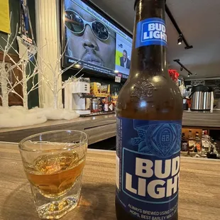 a bottle of bud light next to a glass of beer