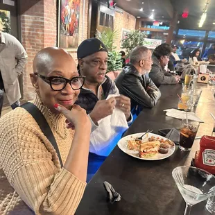 Family enjoying food, conversation and tv at the bar as we waited for others to arrive for our meet up.