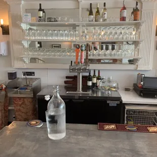 a bar with wine glasses and bottles