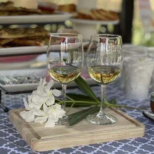 two glasses of white wine on a tray