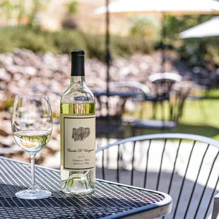 a glass of white wine and a bottle of wine on a table