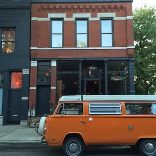 an orange van parked in front of a building