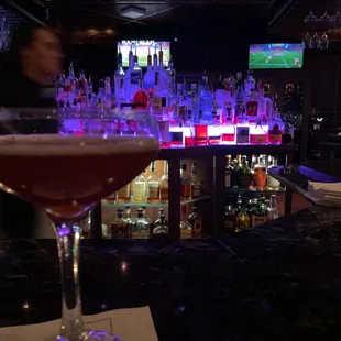 a glass of wine on a bar