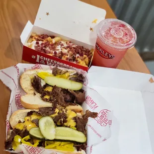 A large "Old Skool Cheeseteak" with Mayo, Pickles, Banana Peppers, and Mushrooms, Ultimate Loaded Fries, and a Strawberry-Peach Lemonade.