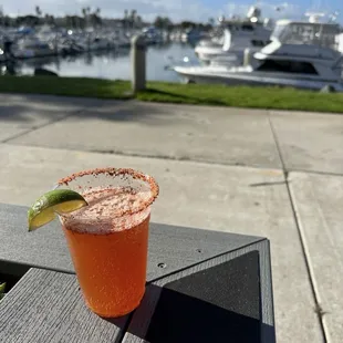 a drink on a table with a view of a marina