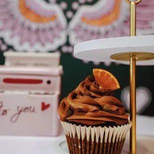 a cupcake with chocolate frosting and a slice of orange