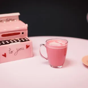 a pink typewriter and a cup of coffee