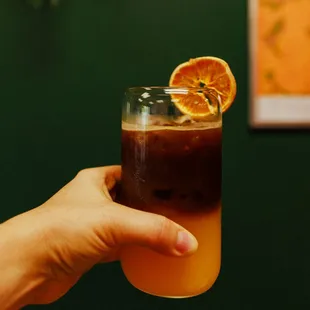 a hand holding a glass of coffee