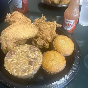 Three golden pieces of tasty southern friend chicken Red beans and rice and warm homemade corn bread.