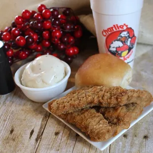 a plate of fried chicken, a roll, a cup of coffee, and cranberries